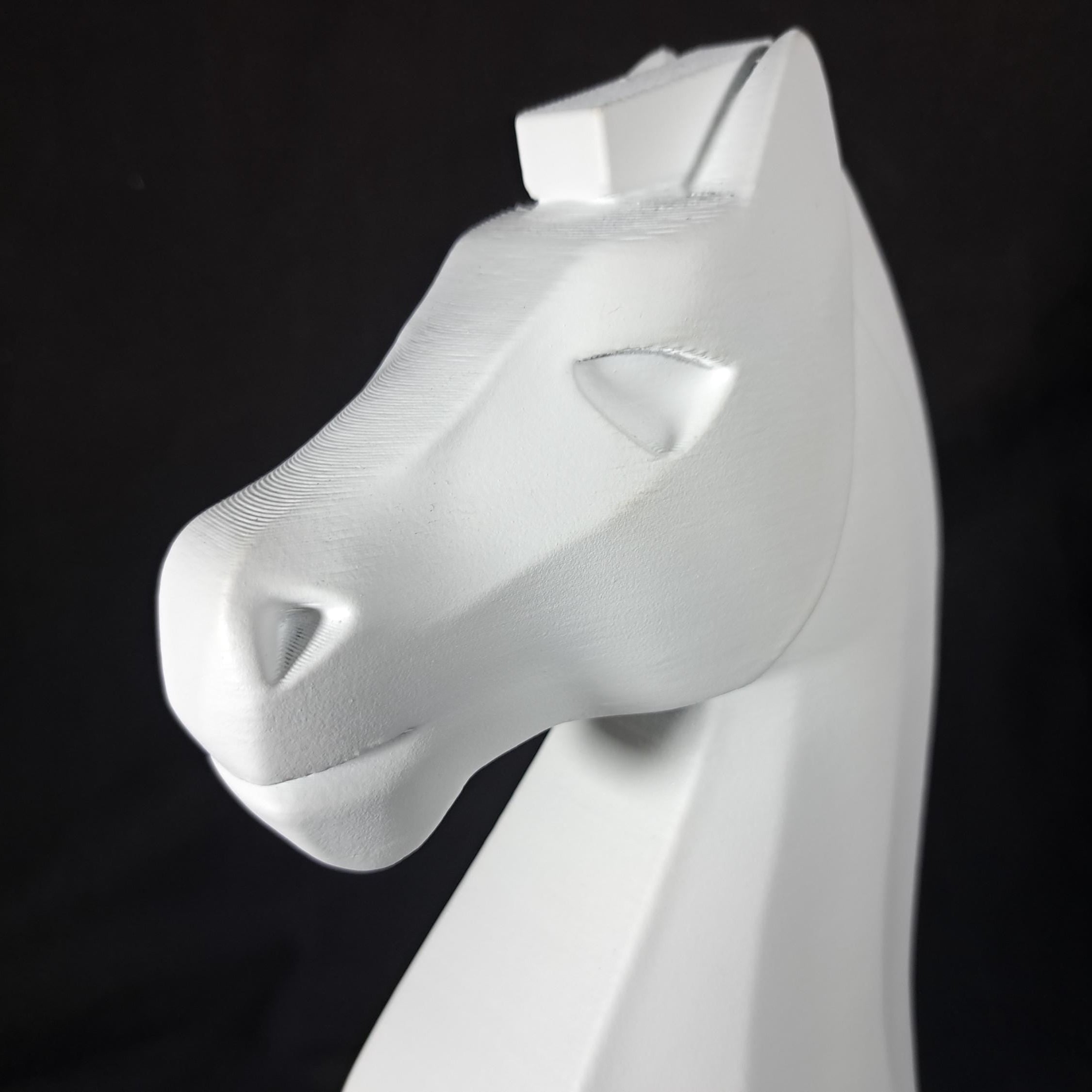 White horse head sculpture on a black background