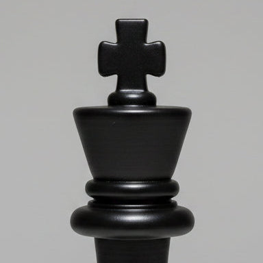 A matte black chess king piece centered on a light gray gradient studio background.
