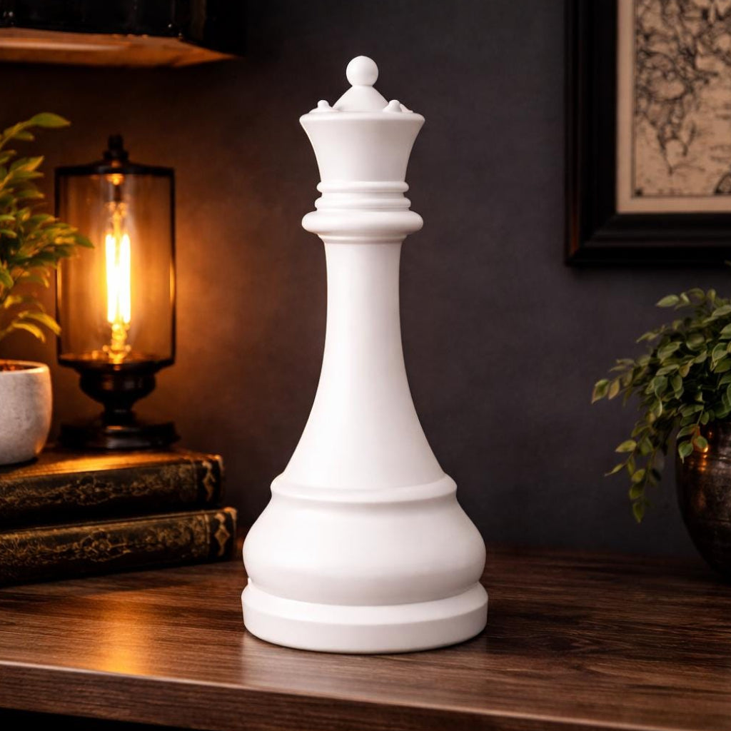 White queen chess piece on a wooden surface with decorative items in the background