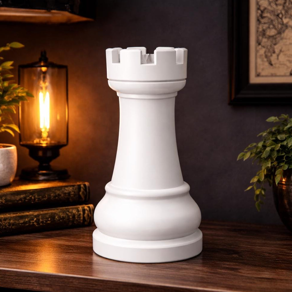 White rook chess piece on a wooden surface with decorative items in the background