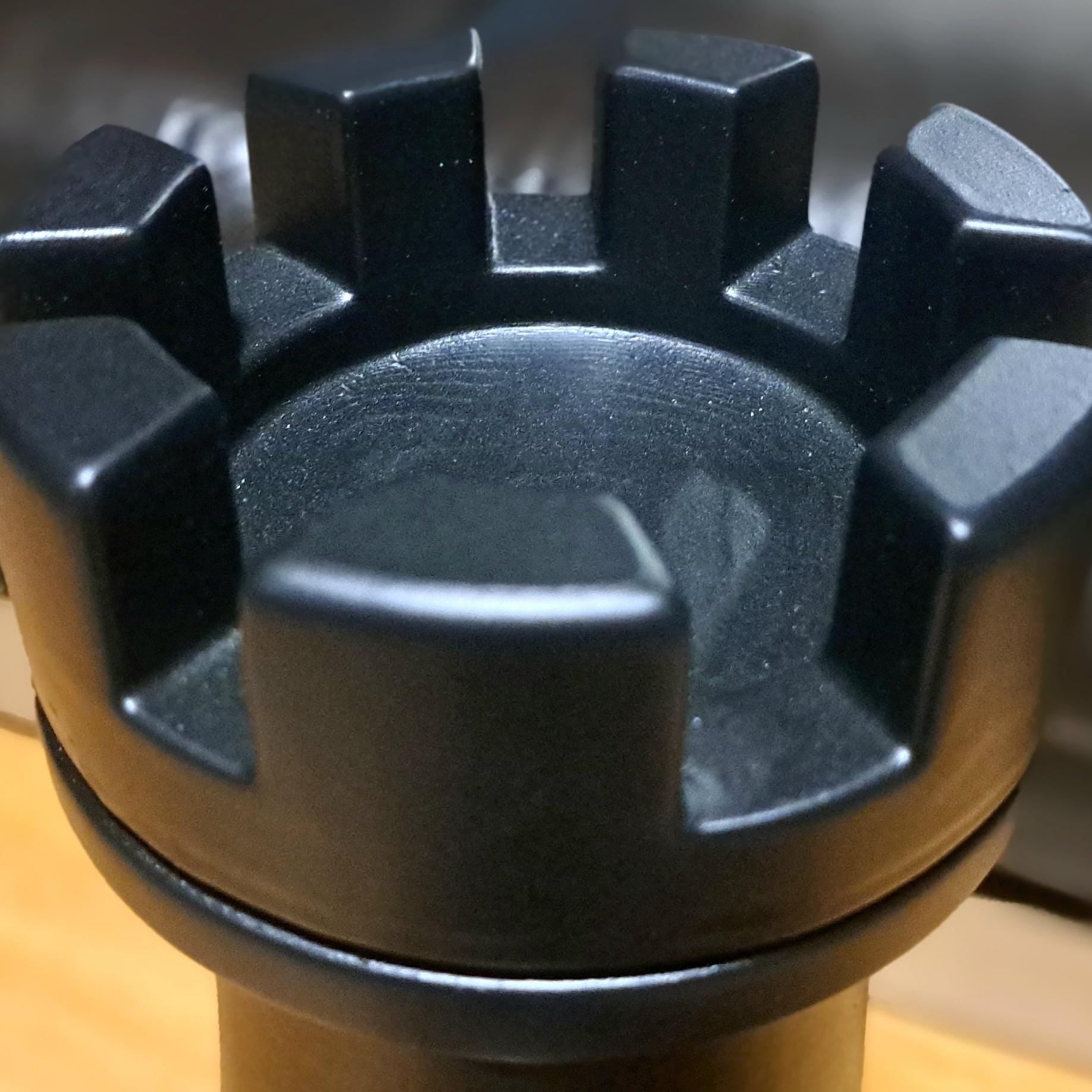 Close-up of a black rook chess piece on a wooden table
