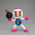 A 3D-printed Bomberman figurine holding a black bomb in an action pose against a plain gray background.