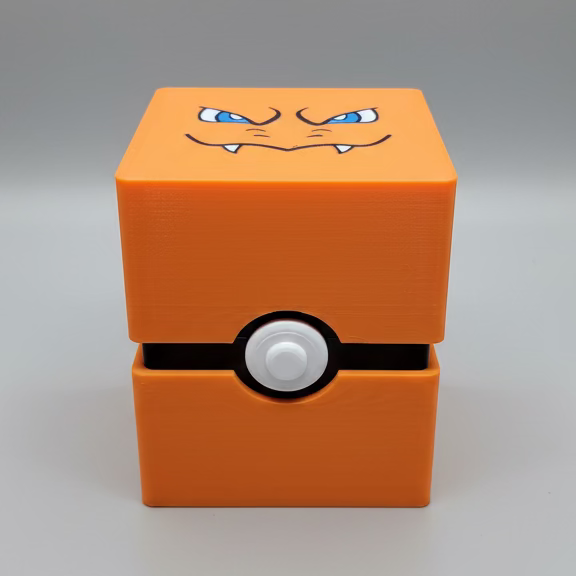 An orange cube-shaped Pokémon Charizard deck box with a printed face on top and a button on the front, sitting on a grey photo backdrop.
