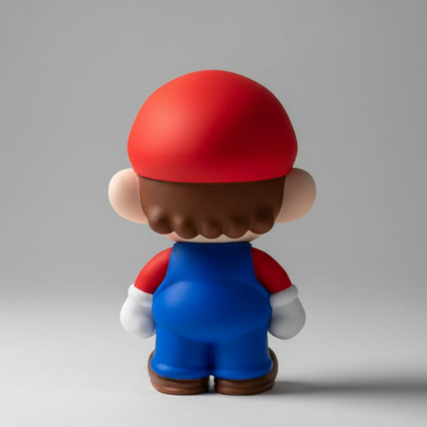 Toy mario figure with a red cap and blue body standing on a grey background.