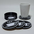 Set of black coasters with coffee cup design on a grey background.