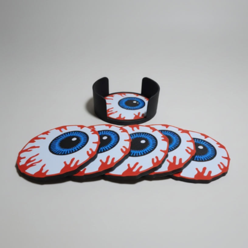 Eyeball-shaped coasters with red and white design on a grey background.