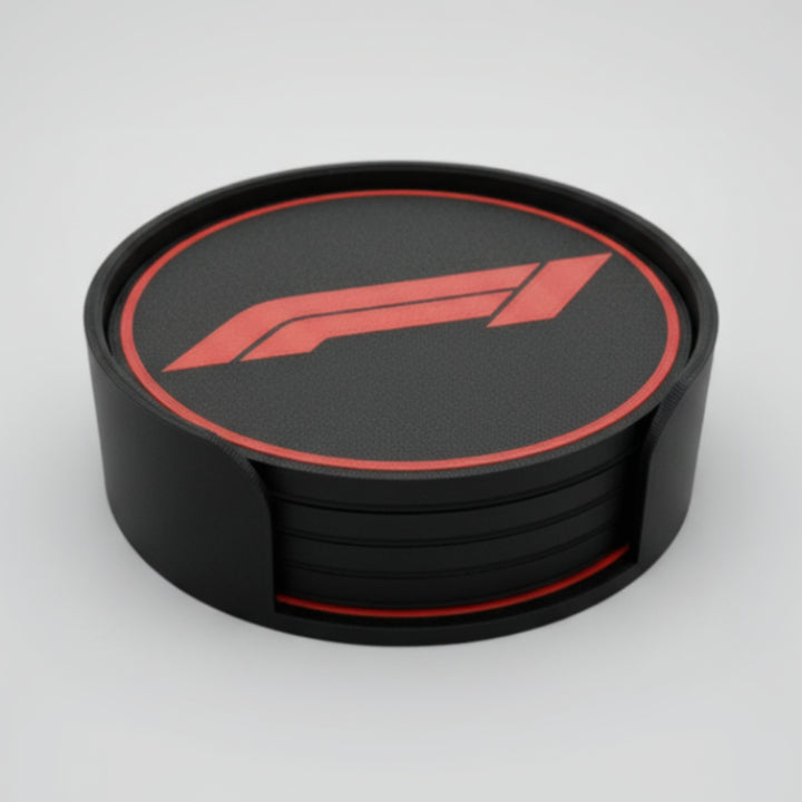 A set of black circular coasters stacked on a grey background, featuring a red Formula 1 logo and red circular border,