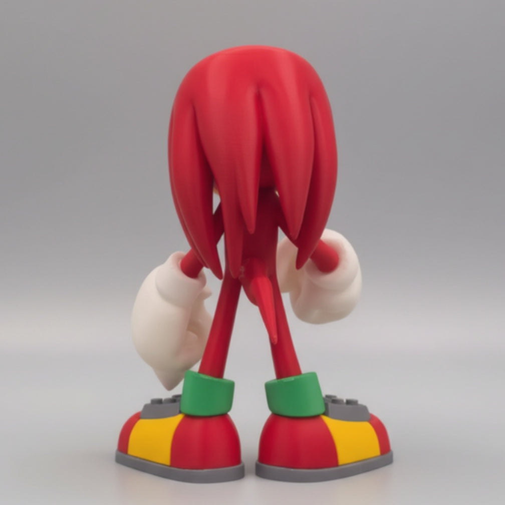 Red animated character Knuckles figurine with long hair and colorful shoes on a neutral grey background.