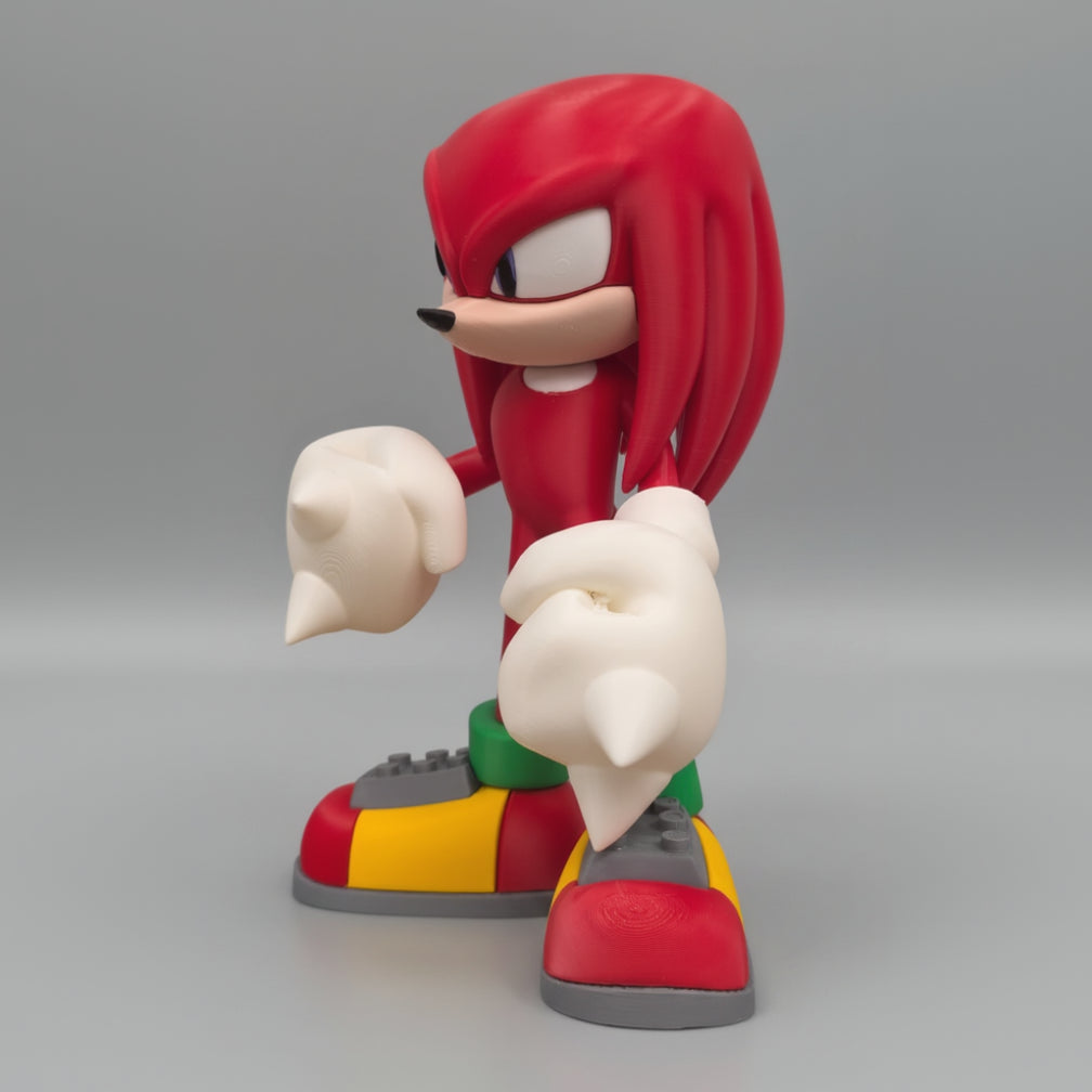 Knuckles the Echidna figurine from Sonic the Hedgehog on a reflective surface with a grey background.