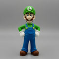 Front view of a Luigi collectible toy figurine standing with hands on hips, showcasing product details on a gray background.