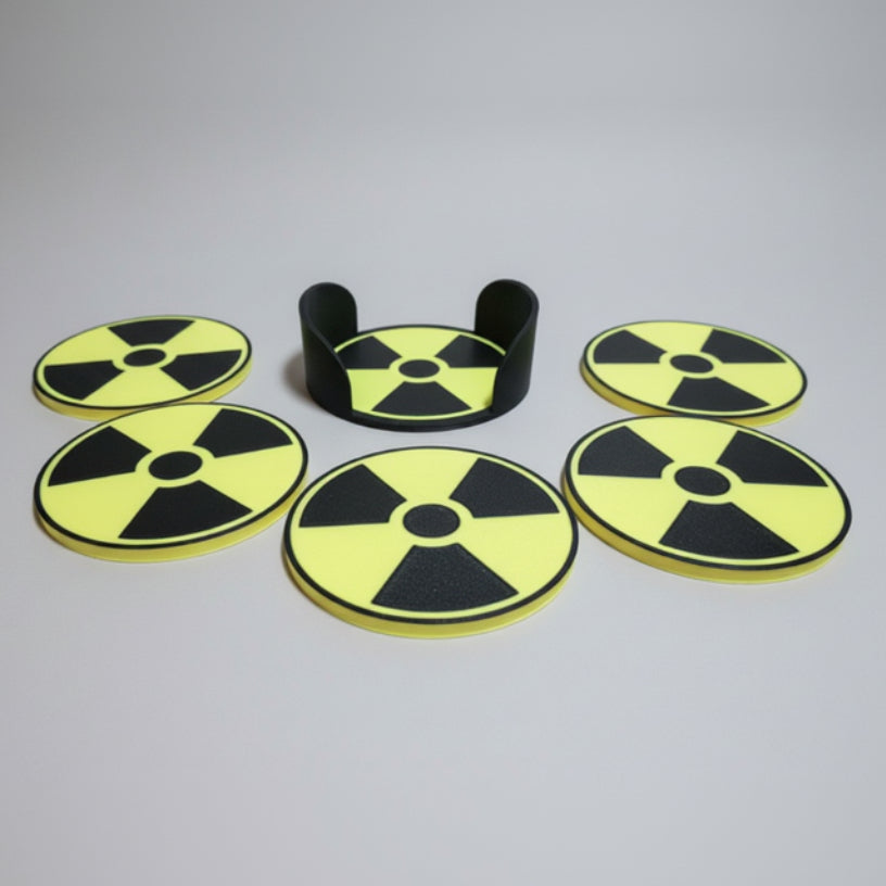 Five yellow and black radiation symbol coasters on a grey background.
