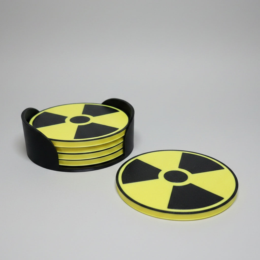 Stack of yellow and black radioactive symbol coasters on a grey background.