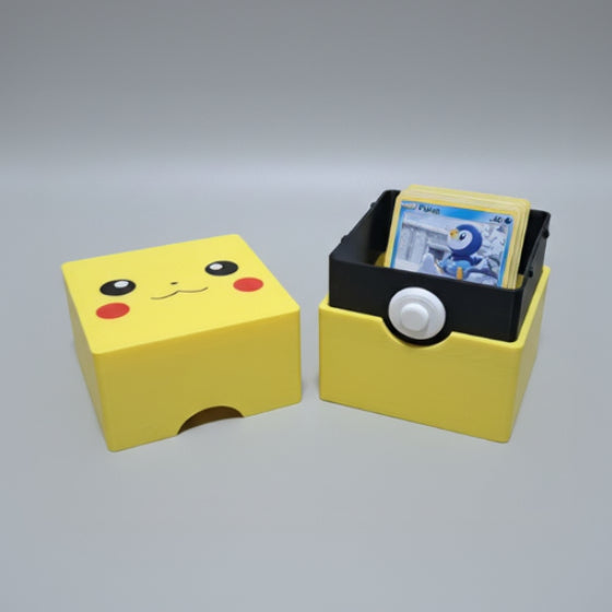 3D printed Pikachu Pokémon deck box open, showing black inner tray loaded with Pokémon cards, yellow exterior with Pikachu face lid and thumb notch.