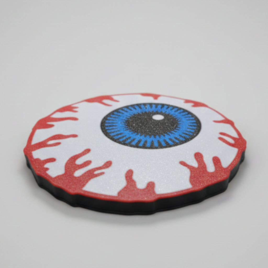 Creepy eyeball coaster on a grey background.