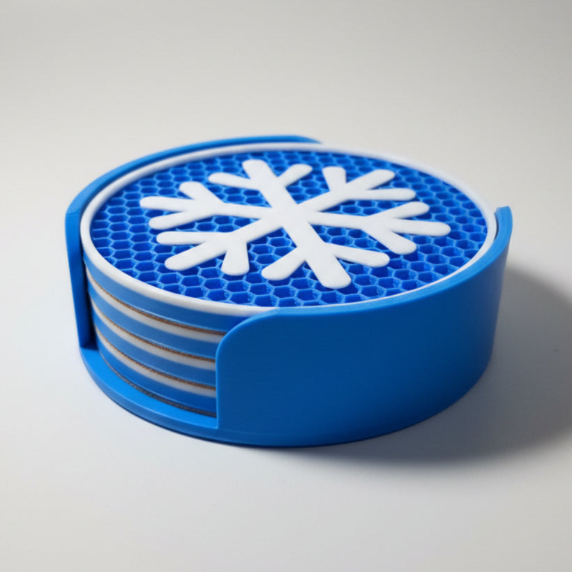Blue and white snowflake coaster set on a grey background.