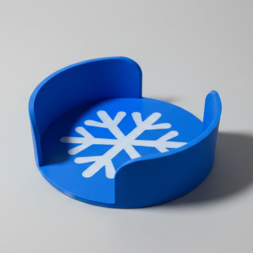 Blue coaster holder with a snowflake design on a gray background.
