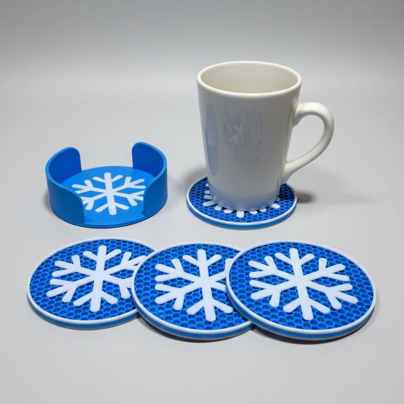 Blue snowflake coasters with a white mug on a grey background.