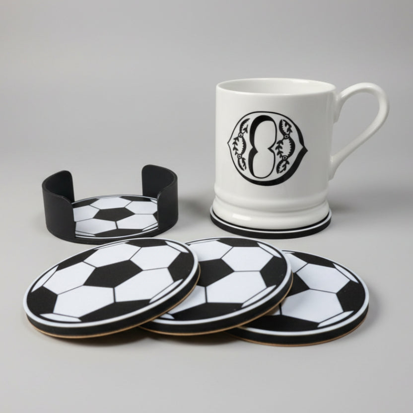 Set of soccer-themed coasters with a mug on a grey background.