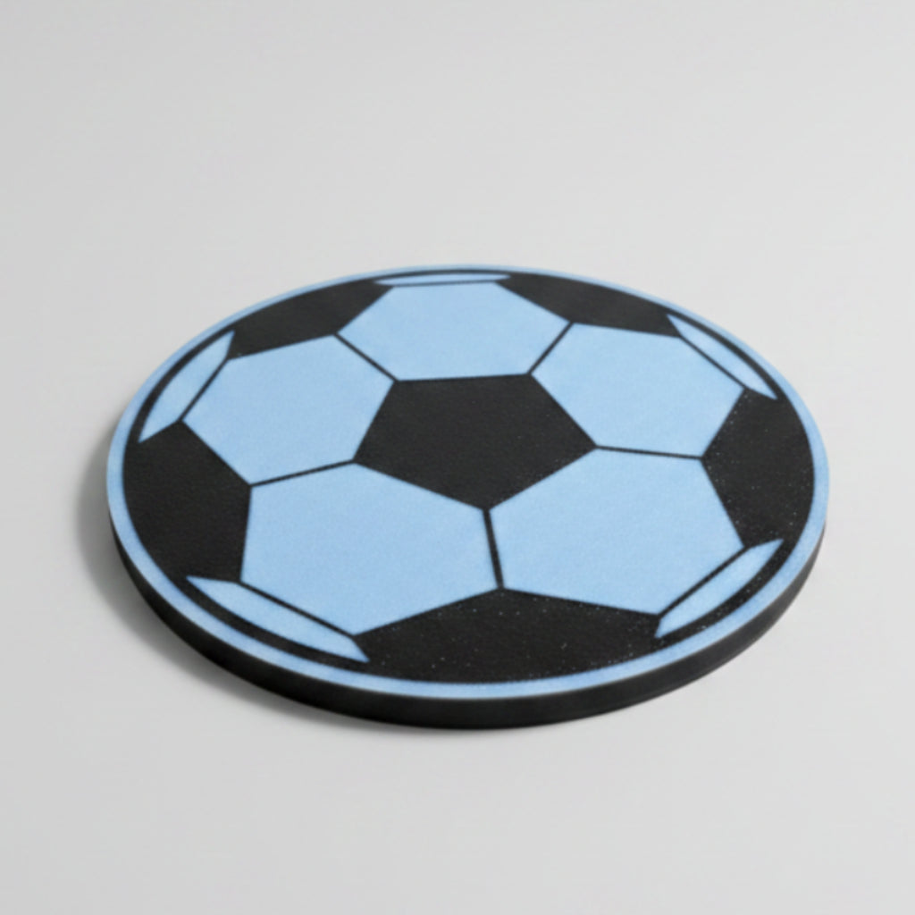 Soccer ball themed coaster on a grey surface.