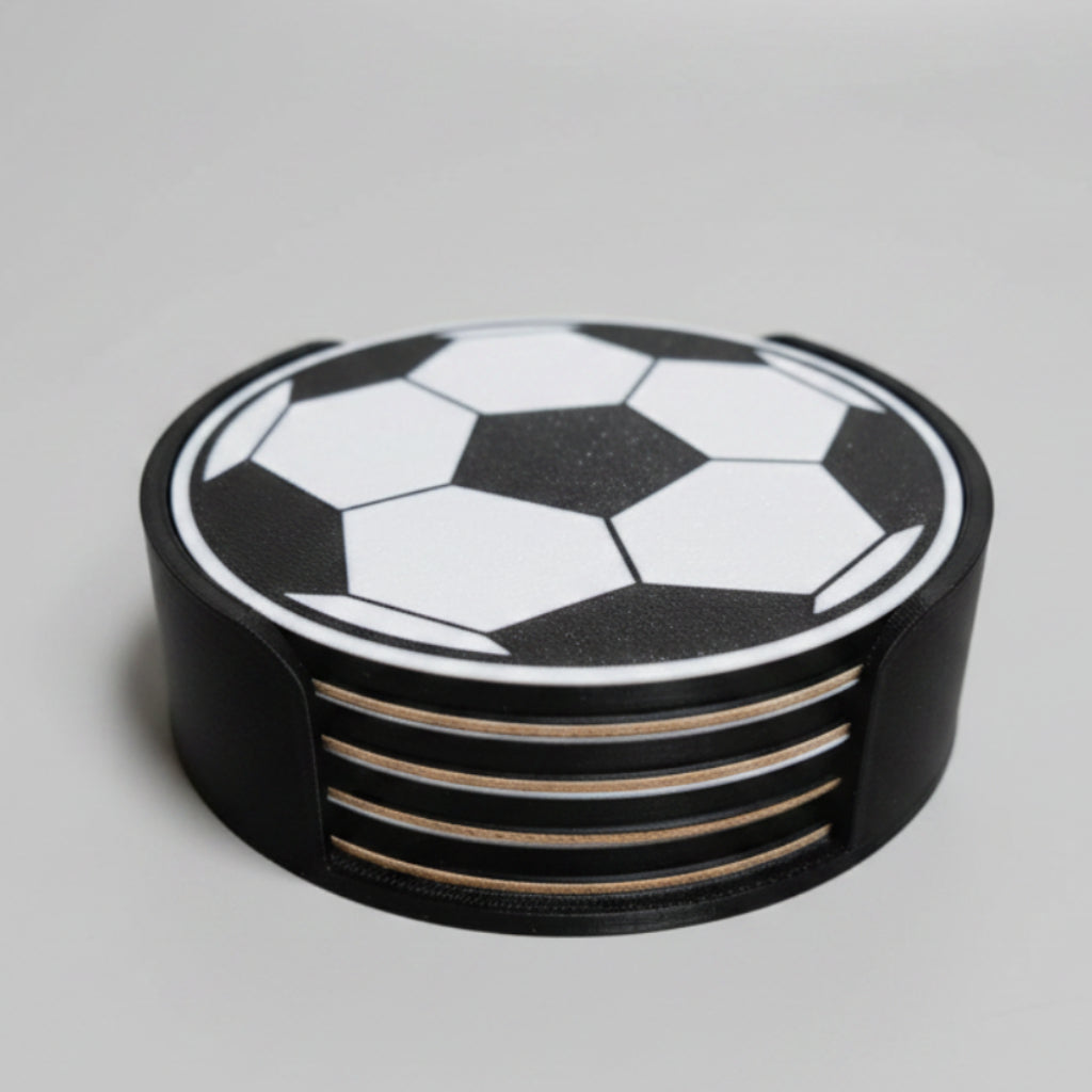 Stack of black and white soccer ball coasters on a grey background.