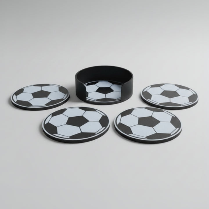 Four soccer ball coasters and matching holding on a grey background.