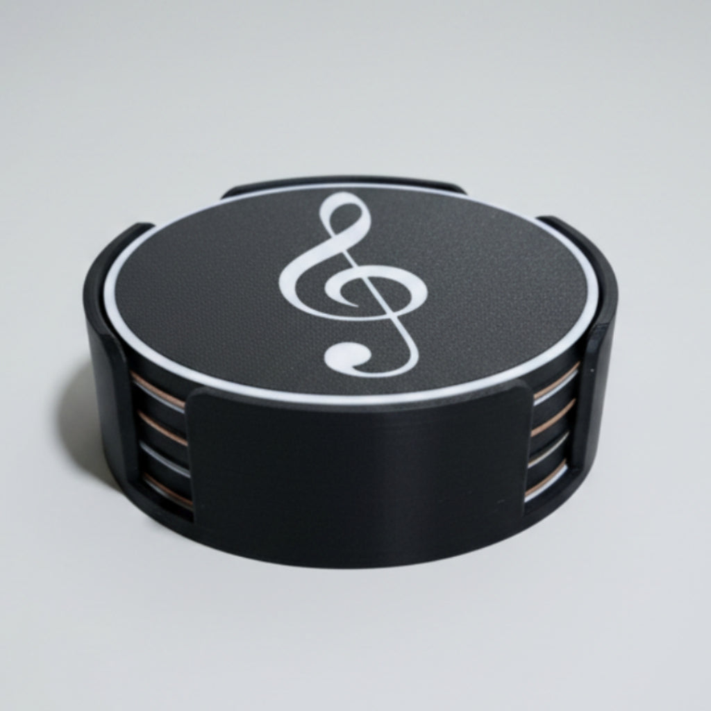 Black and white treble clef symbol coaster set on a grey surface.