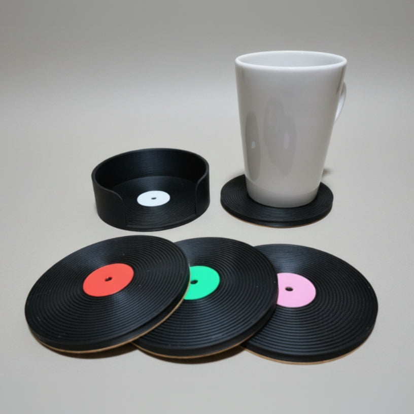 Vinyl record coasters on a grey surface with a white mug.