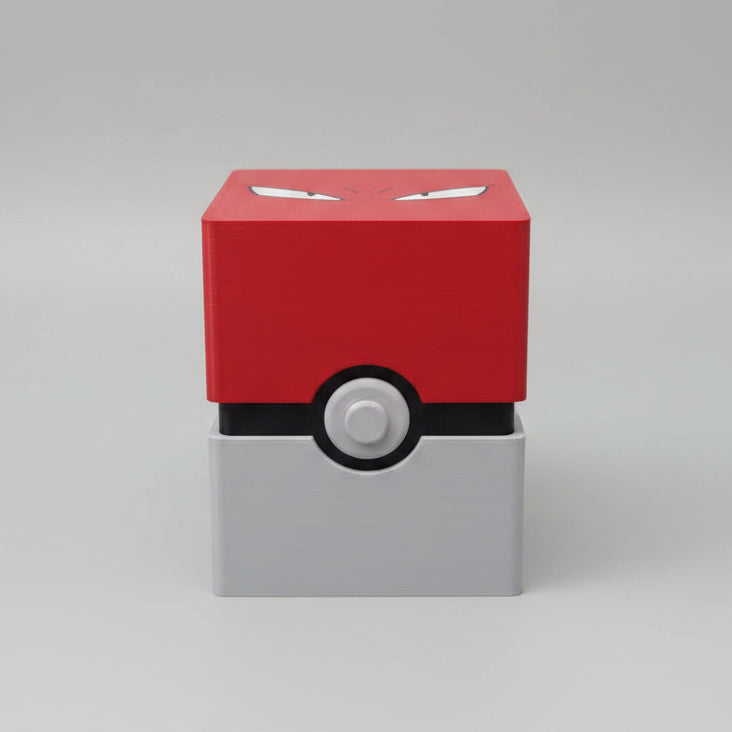 3D printed Poké Ball-style trading card deck box closed, red angry-eyes lid on white and black base with button detail, studio shot.