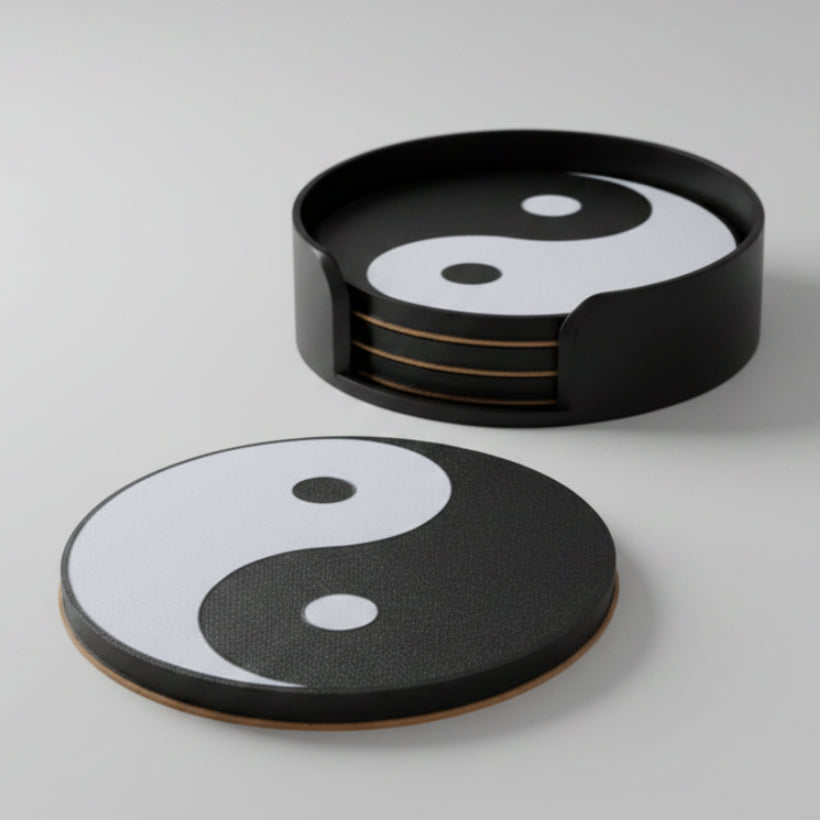 A set of round coasters with a black and white yin-yang design, shown with one coaster standing in a black holder and another lying flat on a light gray background.