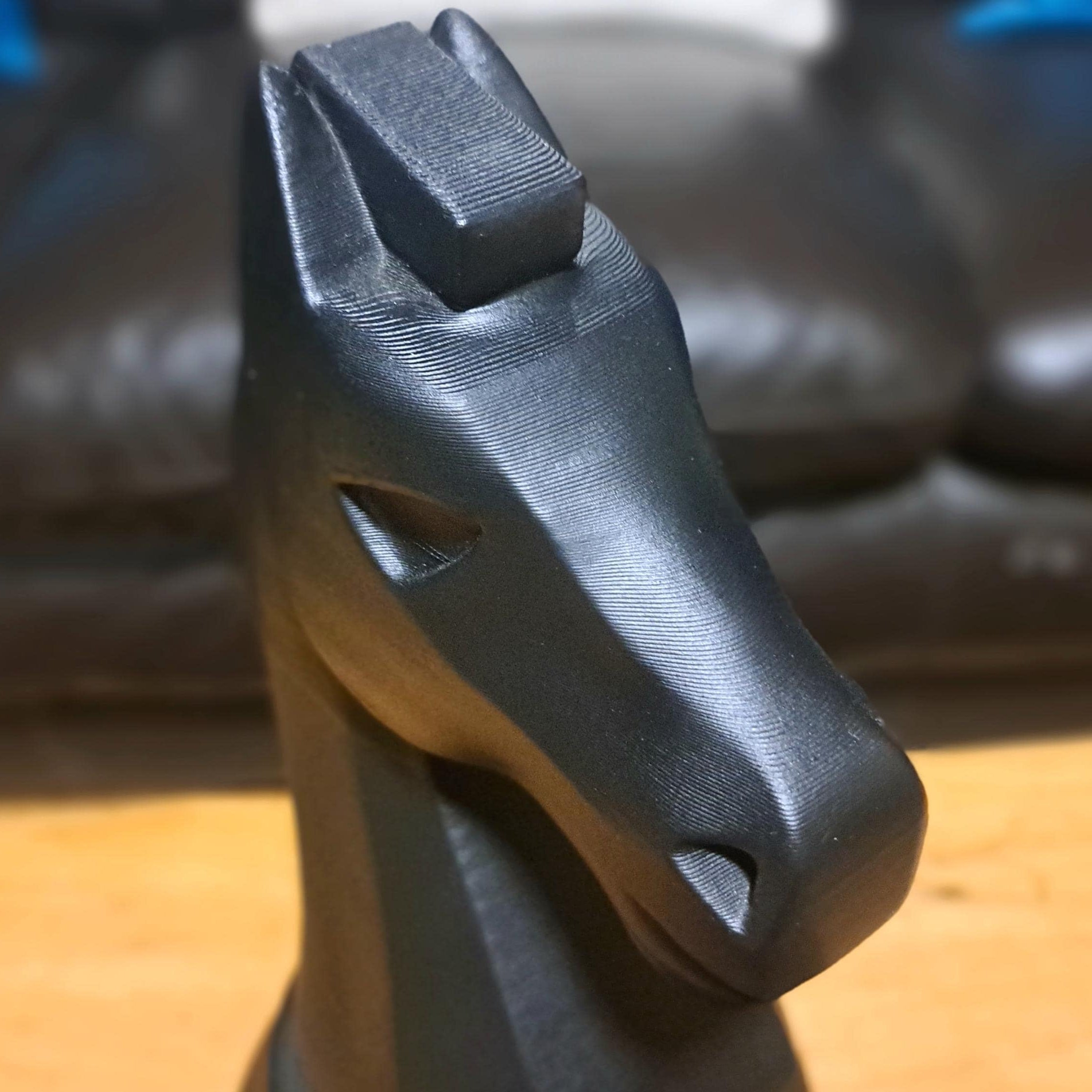 Large black knight chess piece on a wooden table