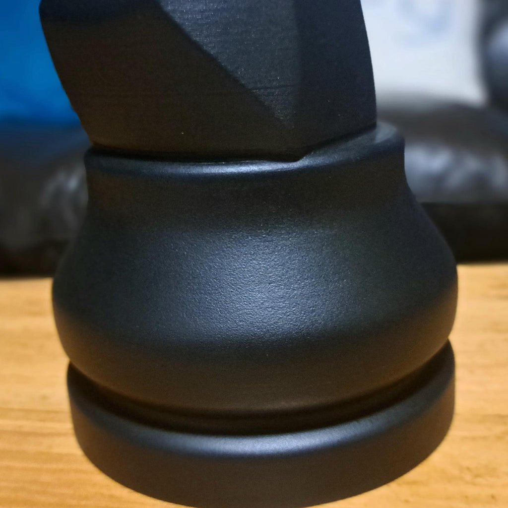 Close-up shot of the bottom of a black knight on a wooden table