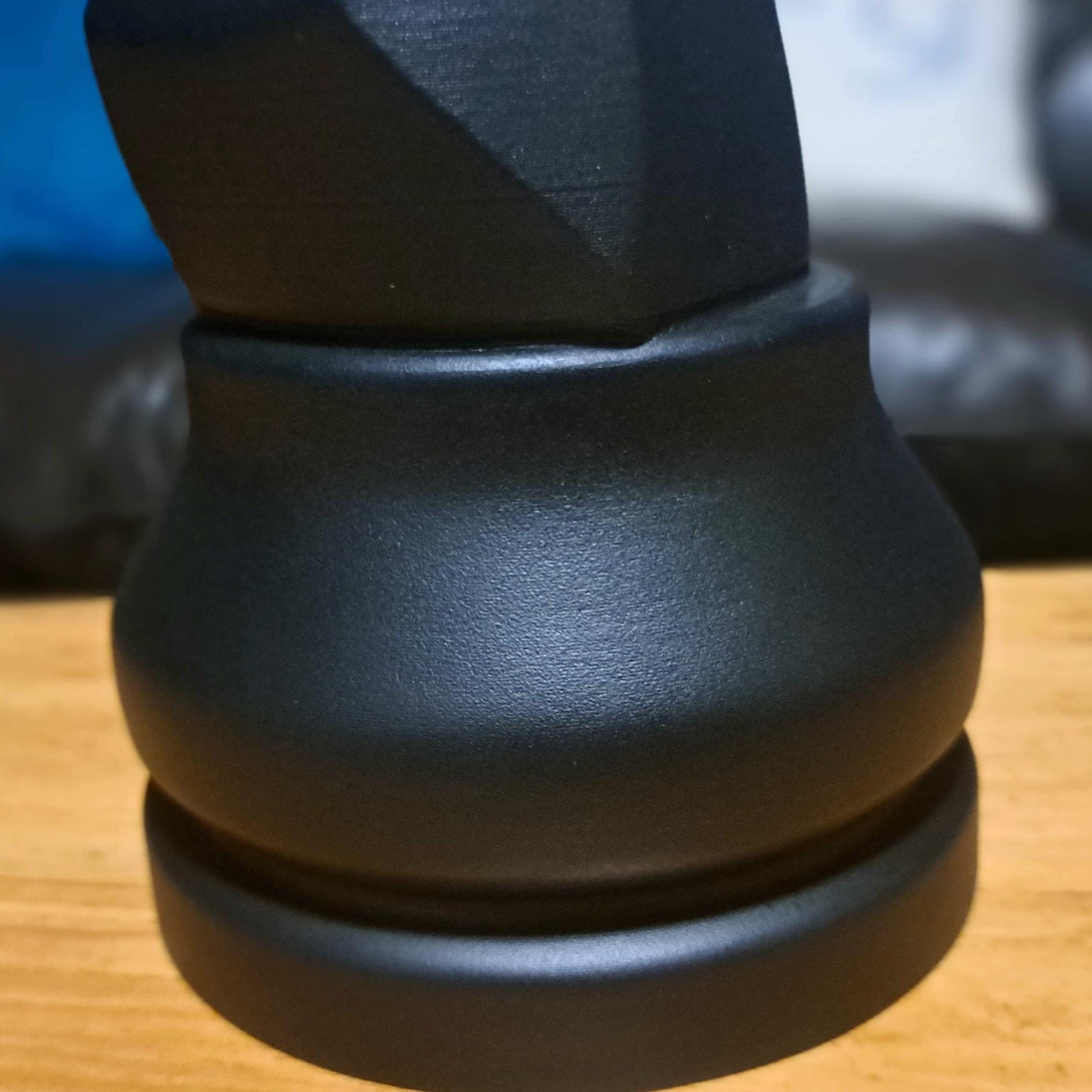 Close-up shot of the bottom of a black knight on a wooden table